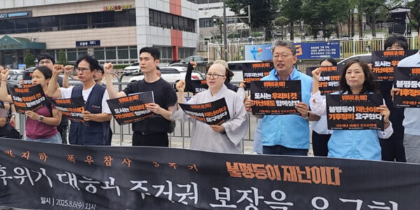 2025년 8월 6일 오후 7시, 서울 홍대입구역 앞에서 37개 시민사회단체가 를 열고 있다. 참가자들은 정부와 서울시가 약속한 반지하 주택 주거 대책을 제대로 이행하지 않고 있다며, 기후 위기 시대에 취약계층의 주거권을 보장하라고 주장했다.