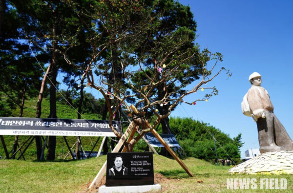 추모비와 추모목, 뒤로 김용균 노동자 추모 조형물이 보인다