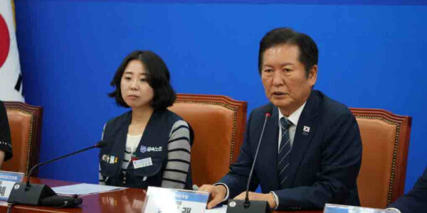 정청래 더불어민주당 대표가 25일 오전 서울 여의도 국회에서 열린 외국인 투자기업 노동자 보호 제도 개선 특별위원회 출범식에서 발언하고 있다. 왼쪽은 고용승계를 요구하며 600일간 고공농성을 이어갔던 박정혜 한국옵티칼하이테크 수석부지회장 모습.