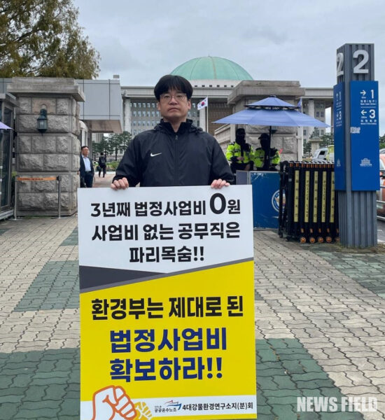 공공운수노조 4대강물환경연구소지회 소속 노동자가 13일 국회 앞에서 '임금체불과 강제휴업의 악순환을 멈추라'고 적힌 피켓을 들고 1인 시위를 진행하고 있다.