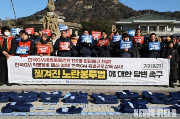 22일 오전 서울 청와대 앞 '한국GM 집단해고 해결 촉구 기자회견'에서 참가자들이 해고 노동자들의 작업복 위에 사원증을 놓는 퍼포먼스를 진행하며 고용승계 이행과 집단해고 철회를 촉구하고 있다.