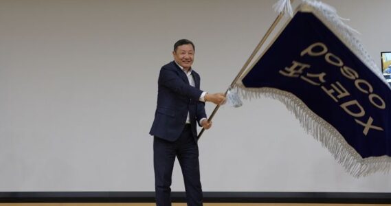 정덕균 포스코DX 전 사장이 재임 시절인 2023년 3월 30일 비전선포식에서 직원대표들로부터 사기를 전달받아 힘차게 흔들고 있다. 사진=포스코DX 제공