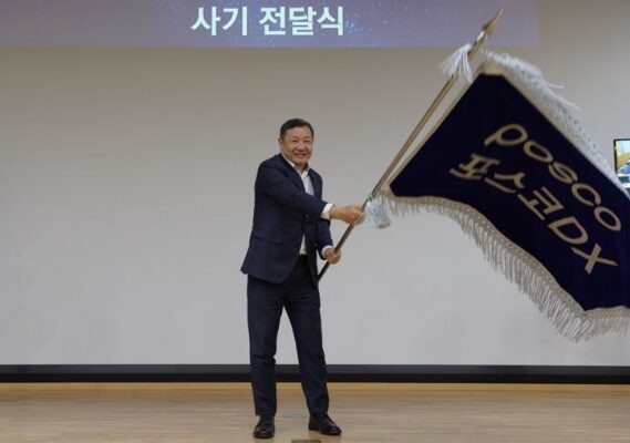 정덕균 포스코DX 전 사장이 재임 시절인 2023년 3월 30일 비전선포식에서 직원대표들로부터 사기를 전달받아 힘차게 흔들고 있다. 사진=포스코DX 제공