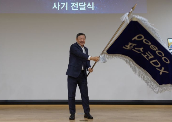 정덕균 포스코DX 전 사장이 재임 시절인 2023년 3월 30일 비전선포식에서 직원대표들로부터 사기를 전달받아 힘차게 흔들고 있다. 사진=포스코DX 제공