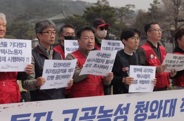 3일 오전 청와대 사랑채 앞에서 열린 기자회견에서 공공운수노조 관계자들이 택시사업자의 조세포탈 의혹을 규탄하며 '택시발전법 개정안 폐기'와 '월급제 쟁취' 문구가 적힌 피켓을 들고 구호를 외치고 있다.