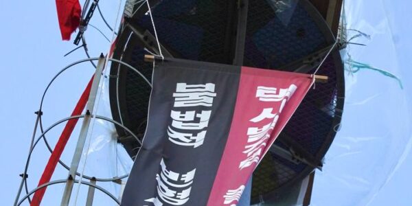 6일 오후 인천시 남동구 소재 맹성규 국회의원 사무실 앞 20m 통신탑에서 39일째 고공농성을 이어가고 있는 고영기 대림교통분회 사무장이 아래에 모인 조합원들을 향해 힘차게 팔뚝질을 하며 구호를 외치고 있다.