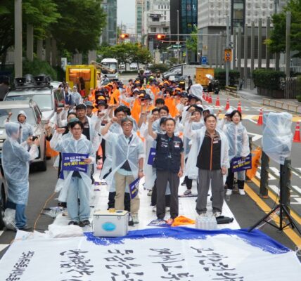 지난 14일 서울 서초동 삼성전자 사옥 앞에서 열린 결의대회에서 삼성화재애니카지부 조합원들이 세차게 내리는 빗속에서 우비를 입고 손피켓을 든 채 사측의 비대면 영상통화 사고 접수 폐지와 단체협약 이행을 요구하며 구호를 외치고 있다.
