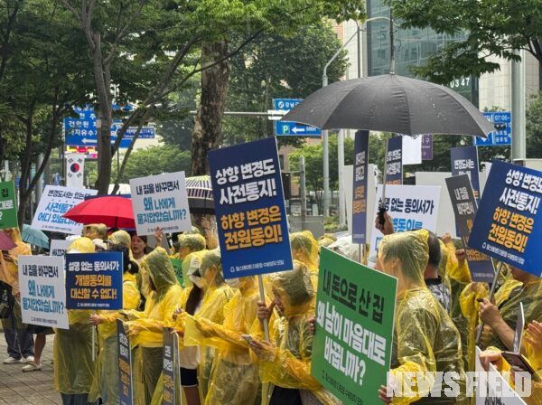 22일 서울 강남경찰서 인근에서 열린 집회에서 우비를 입은 '힐스테이트 더 운정' 수분양자들이 비를 맞으며 '상향 변경도 사전통지, 하향 변경은 전원동의', '설명 없는 동의서가 개별동의를 대신할 수 없다', '내 돈으로 산 집, 왜 남이 마음대로 바꿉니까' 등이 적힌 피켓을 들고 있다.