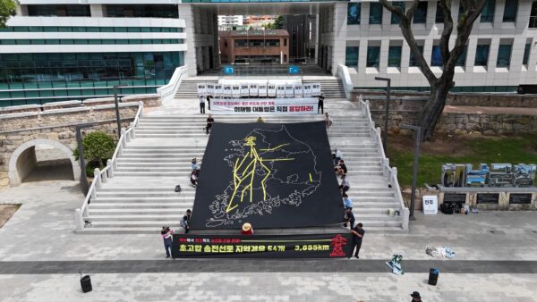 30일 오전 전남 해남군청 앞 계단에서 열린 ‘용인 반도체 산단 재검토 및 초고압 송전탑 반대 전국 대행진’ 출정식에서 참가자들이 대한민국 지도 위에 초고압 송전선로 경유 노선을 표현한 대형 현수막을 펼치고 퍼포먼스를 진행하고 있다.