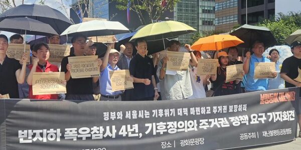 7일 오전 서울 종로구 광화문광장 이순신 장군 동상 앞에서 열린 '반지하 폭우참사 4주기 기자회견'에서 참석자들이 기후위기 대응과 공공임대주택 확대 등 주거권 보장을 촉구하는 피켓을 들고 있다.